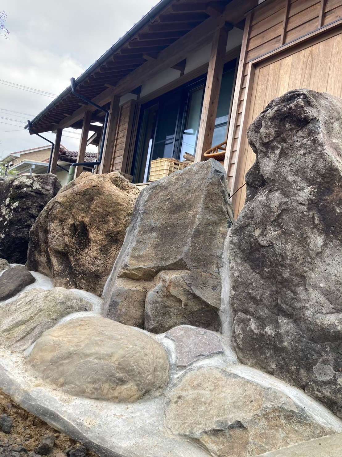 石積みの庭が映える<br />鎧張り壁の家