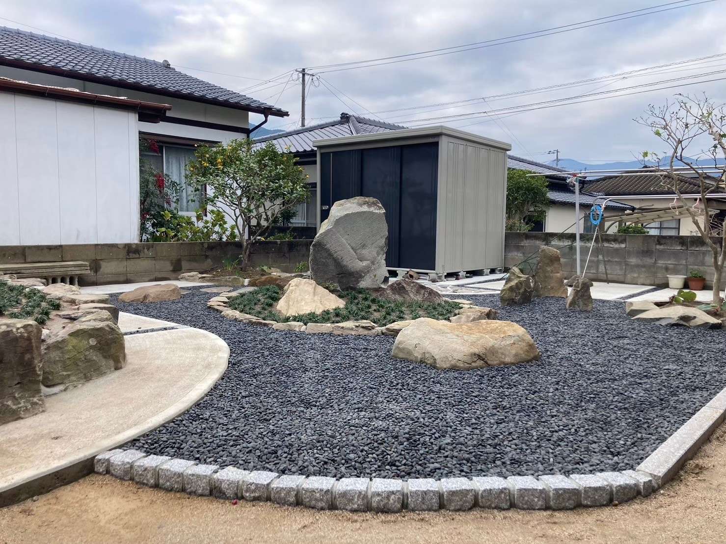 石積みの庭が映える<br />鎧張り壁の家